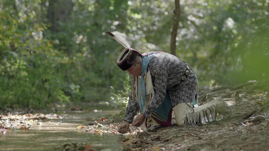 Tribal man rinsing his hands in a stream