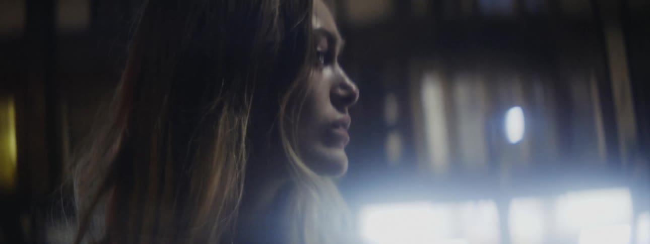 Blonde woman looks over her shoulder in building