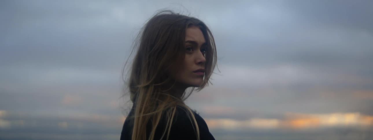 Wind blows through a womans long hair while she stands outside