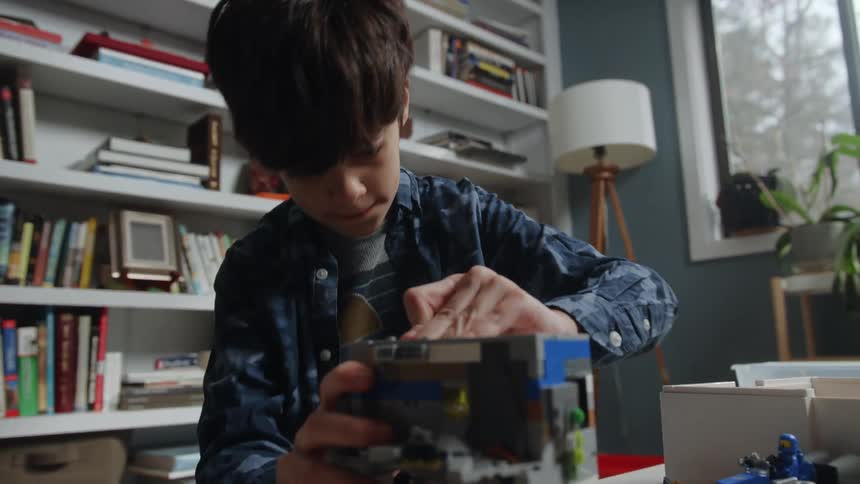 A young boy builds with lego at home