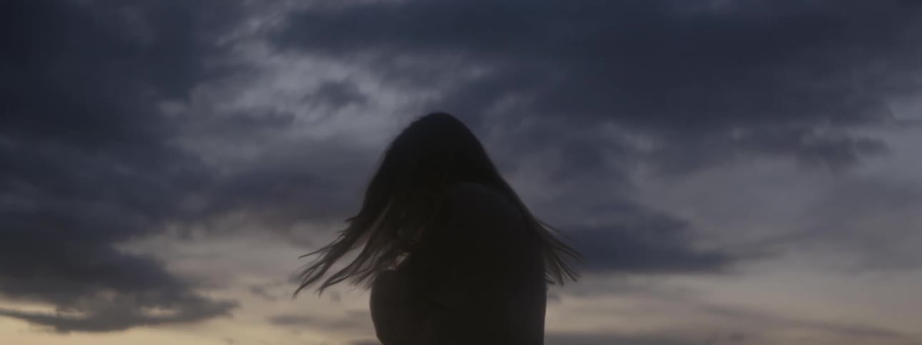 A woman spins in circles as the sun sets