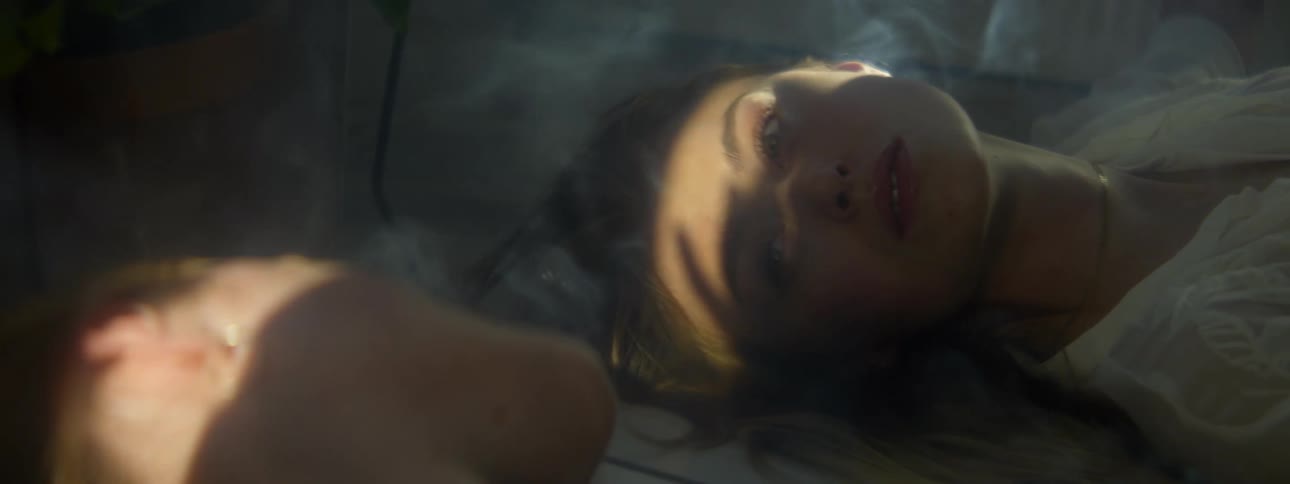 A man and woman stare at each other while lying at the bottom of a pool