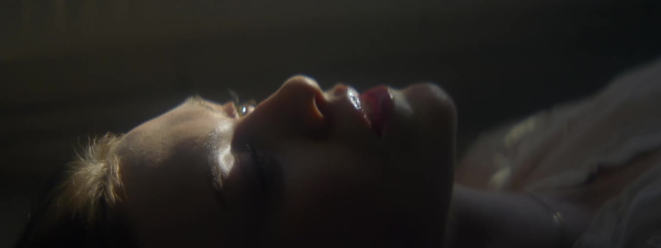 Thoughtful face of a woman lying down lit by the sun
