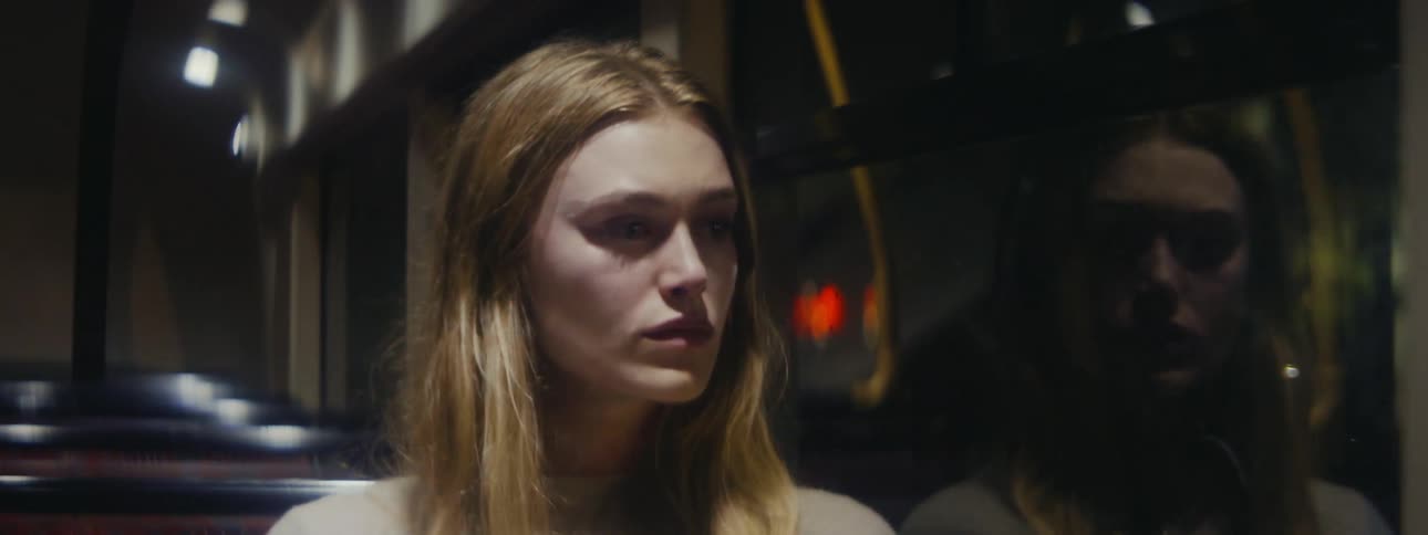 A woman looks out the window while riding the bus