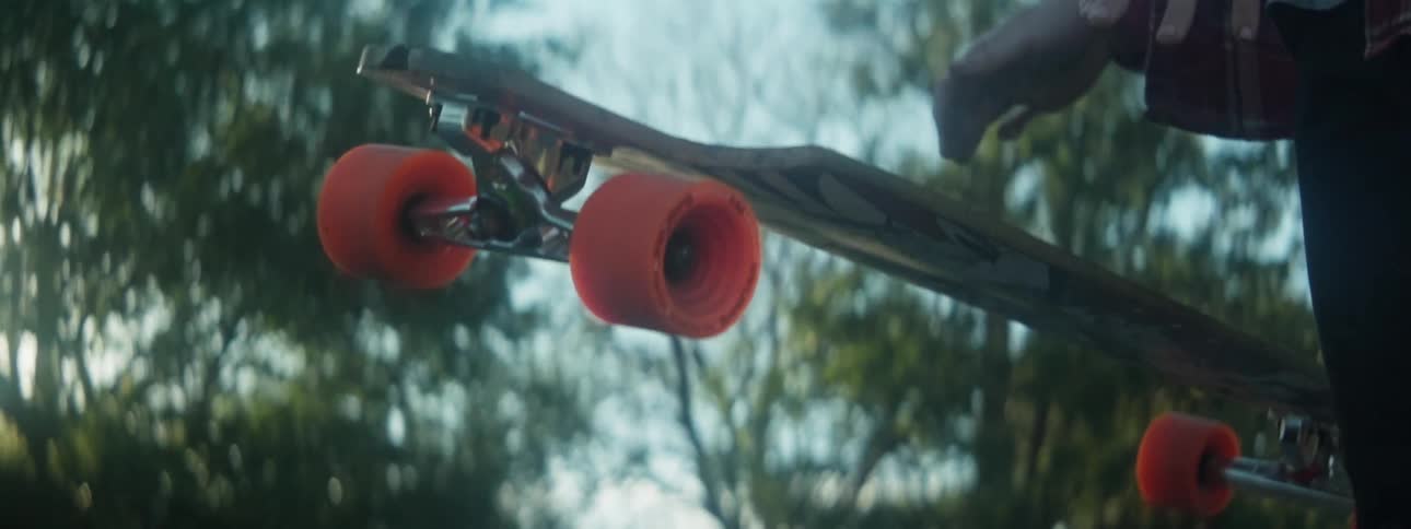 A person drops a skateboard outdoors
