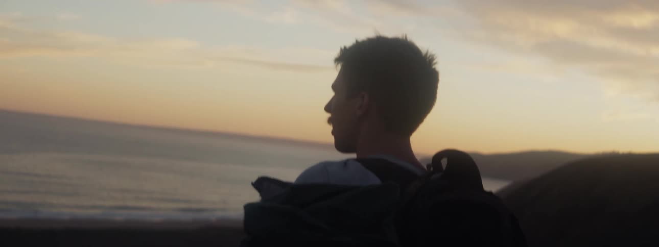 A man on the beach walks towards the water