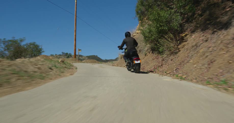 A person drives a motorcycle on a curvy road