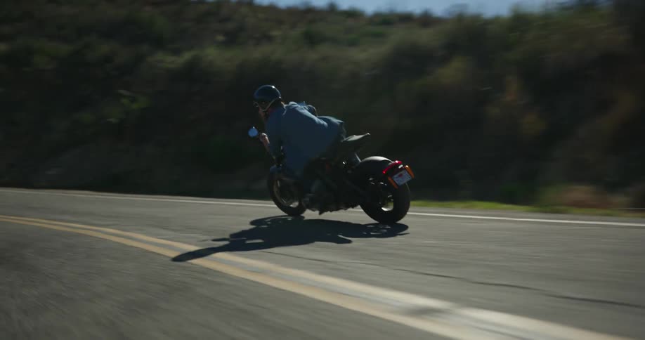 A person rides a motorcycle down a curvy road