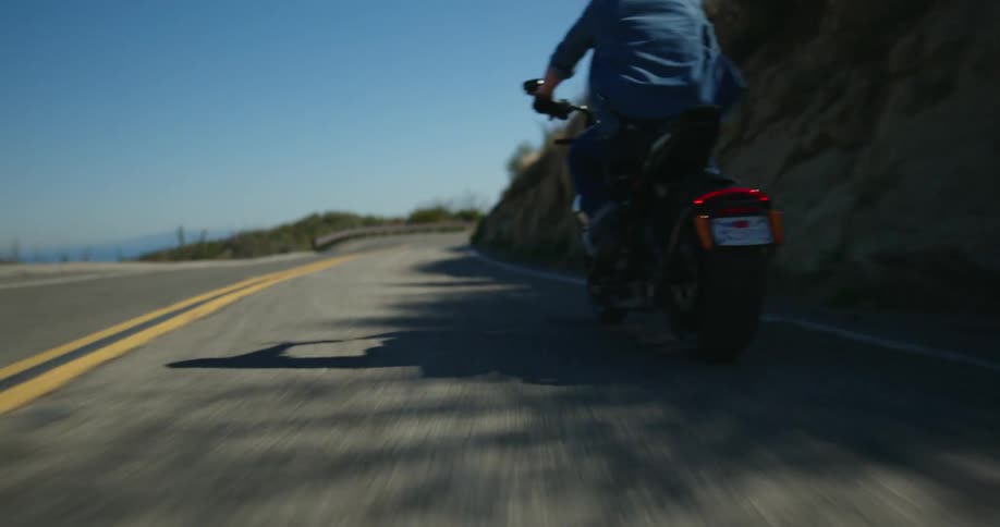A man drives a motorcycle down a street