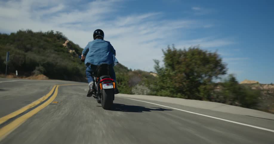 A man is riding a scooter on the road