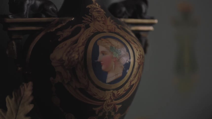 A painted decorative piece hangs on a wall