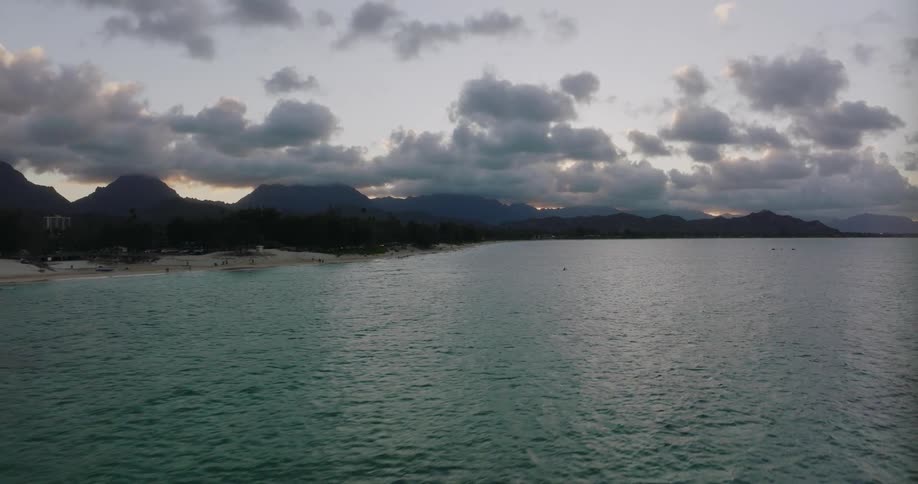 An aerial view of the ocean and beach as the sun sets