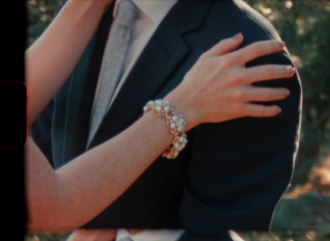 A young couple is getting married outdoors in the middle of the day in super 8 film