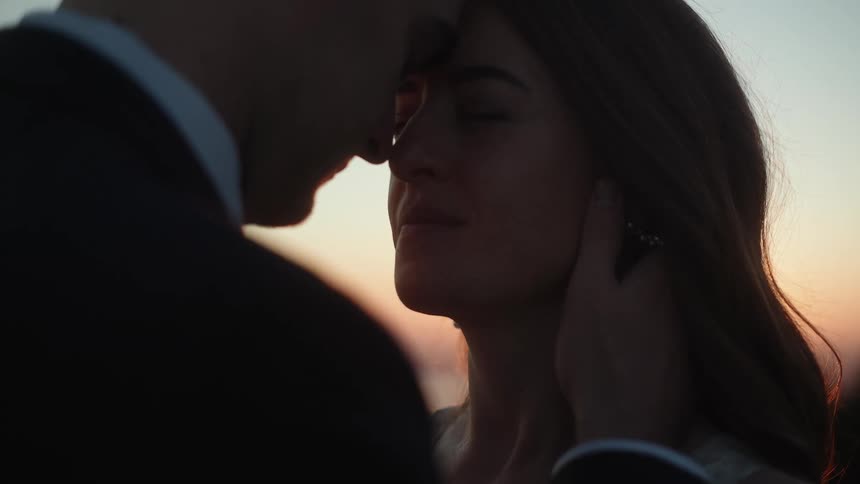 A man and woman touching their foreheads together romantically