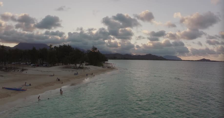 The sun has set in the sky above a relaxing beach area next to a calm ocean