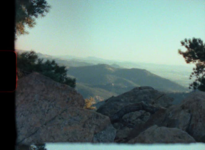 Landscape of mountain range from behind rocks on high mountain vintage super 8 film