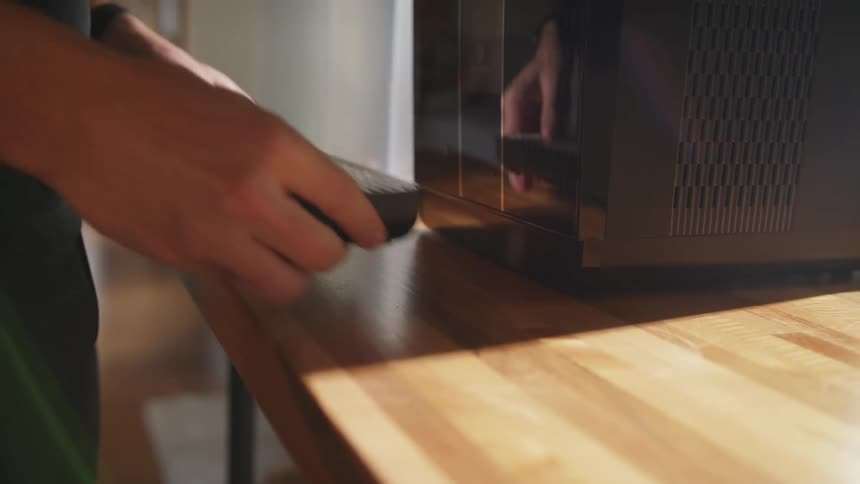 A man puts a water dispenser on the back of a machine