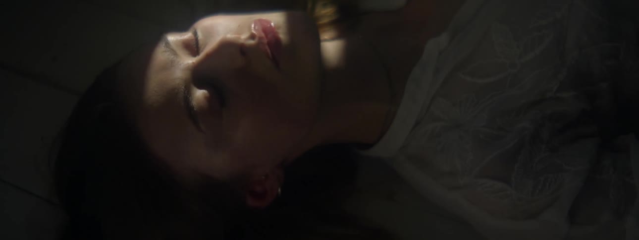 Close up of the face of a beautiful woman under the shadows resting on a dark room