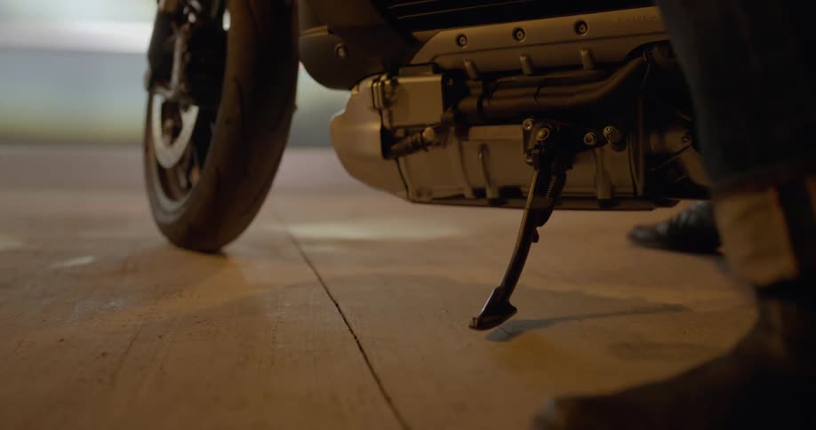 A person parks their motorcycle