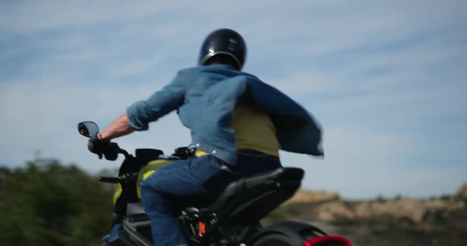 Man wearing helmet driving his motorcycle on a highway during a sunny day