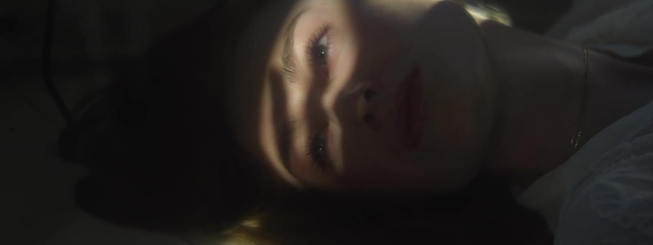 A woman is resting with shadows flickering on her face