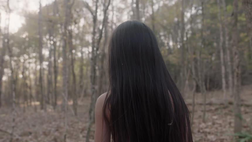 A native american child studying their surroundings in the woods