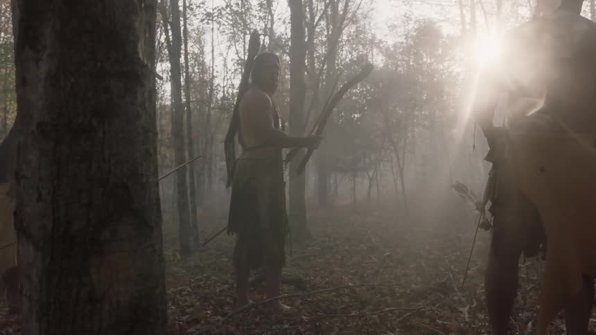 Tribal people in a forest at sunset
