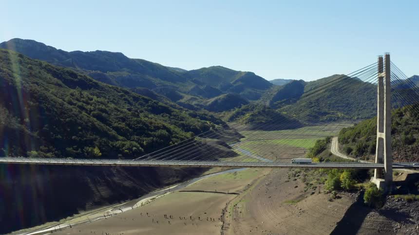 Aerial view of traffic driving on a bridge over a valley in the mountains in the north of Spain