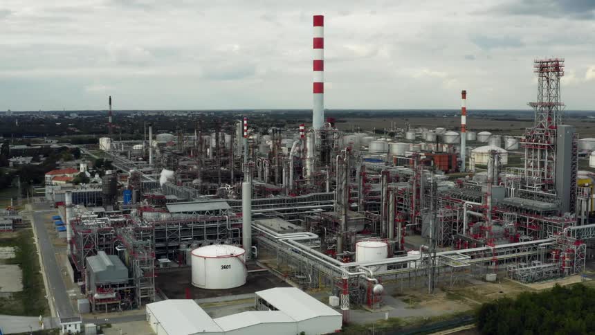 Storage tanks are scattered throughout a power plant under an overcast sky in Eastern Europe
