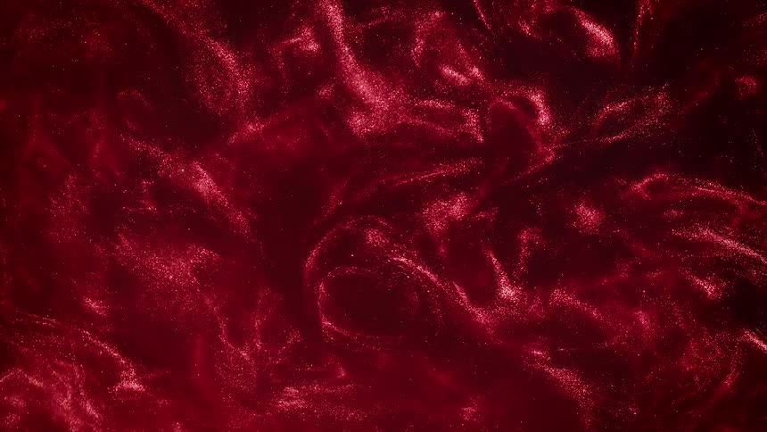 A glittering organic red substance is swirling as it ripples and moves