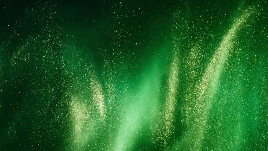 Gold glitter stars move in the green and yellow aurora twinkling into the darkness