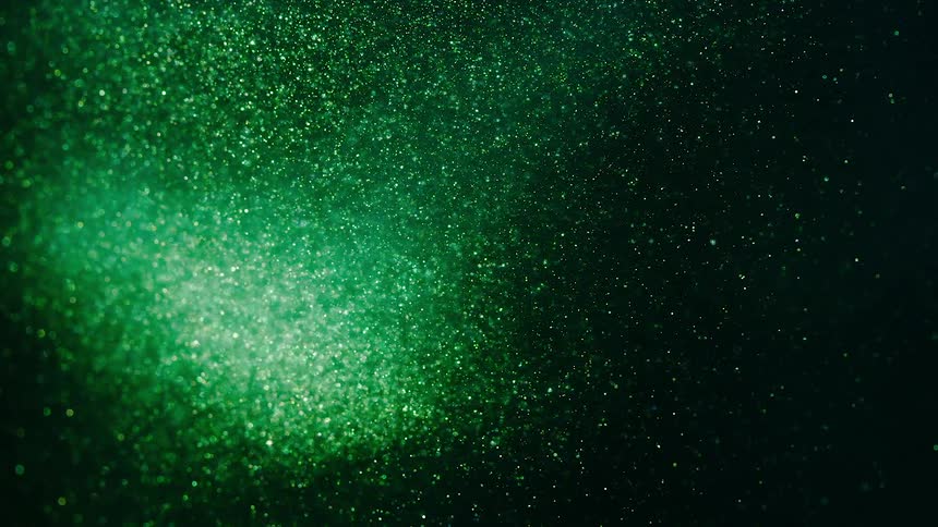 Tiny particles move in the darkness as they are illuminated with green light