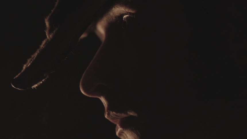 A man looks up in a dim room