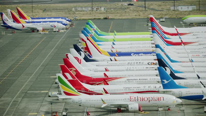 Aerial view of colorful passenger airplanes parked on an airfield at daytime