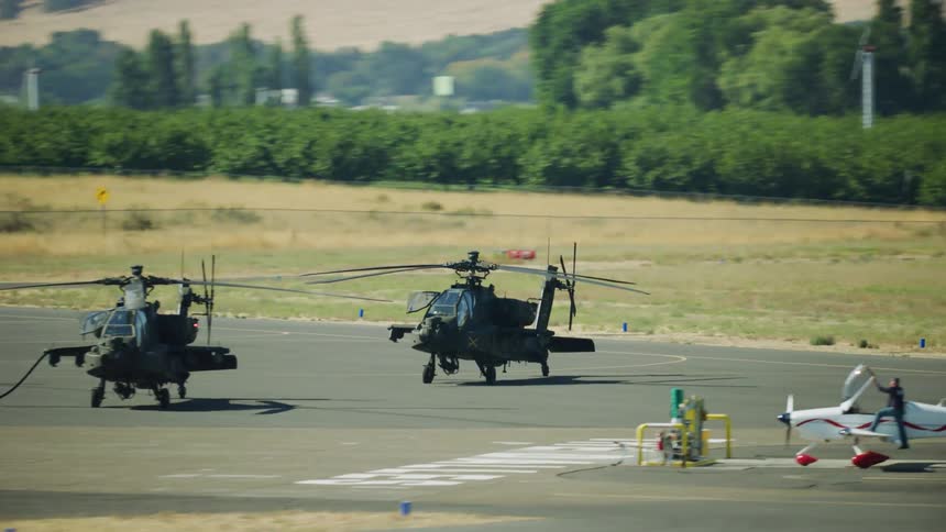 Two AH-64 Apache helicopters receive fuel before beginnig another aerial patrol