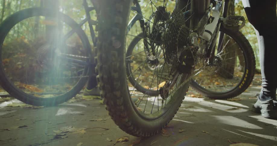A man and woman get on their bikes and start to ride