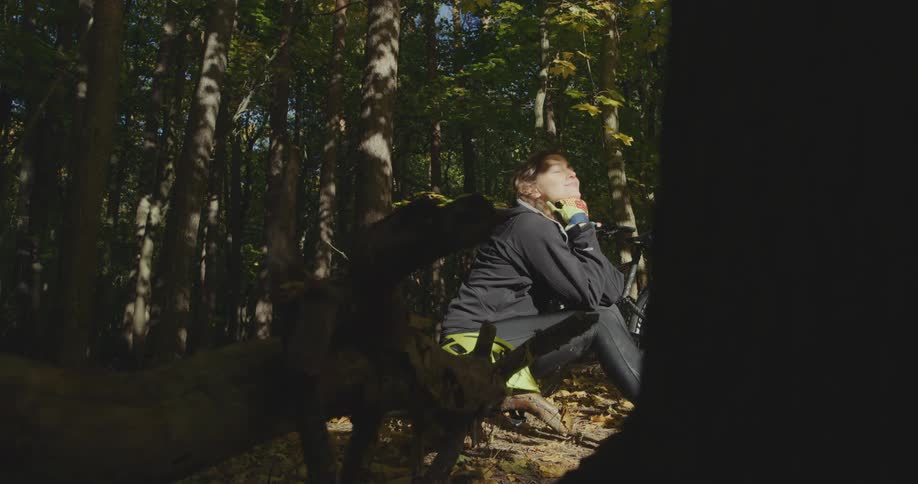 A woman sitting outside in a forest