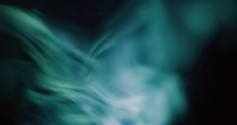 White smoke twisting and swirling up against a black background