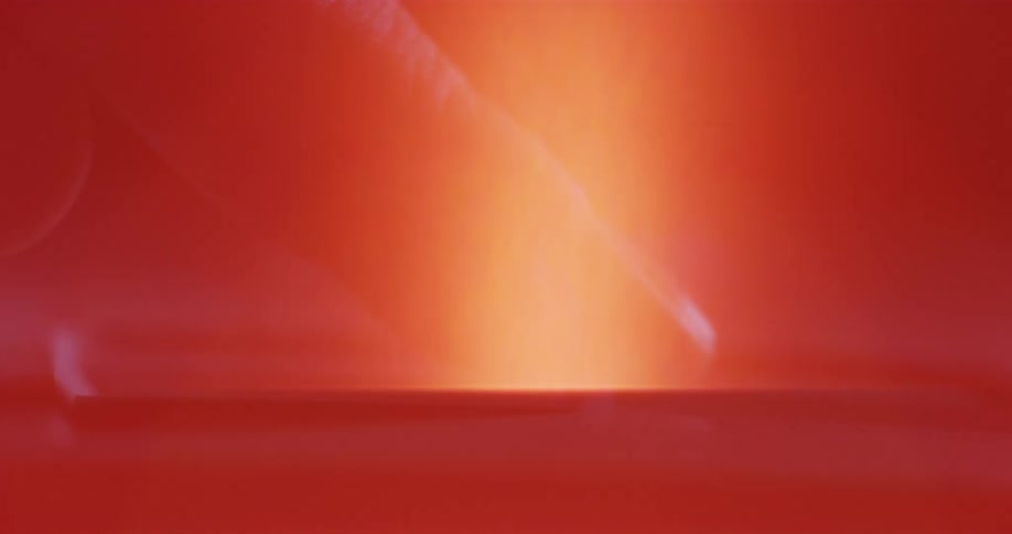 An orange and red glow fill the environment as a ghostly image of a persons finger moves across the area like a mirage