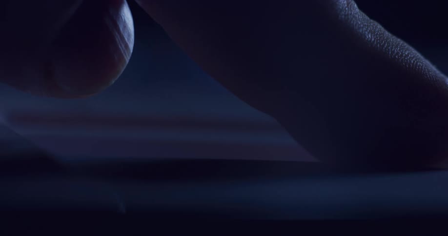 A person slides a button on a machine as a bright light flashes