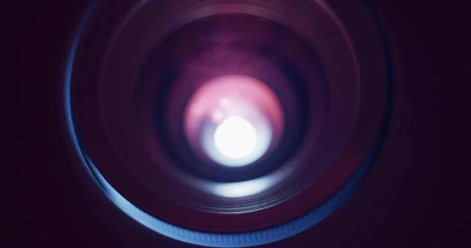 A bright light shines through a camera lens