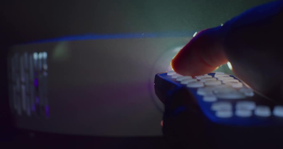 A bright light turns on when a man pushes a button a remote