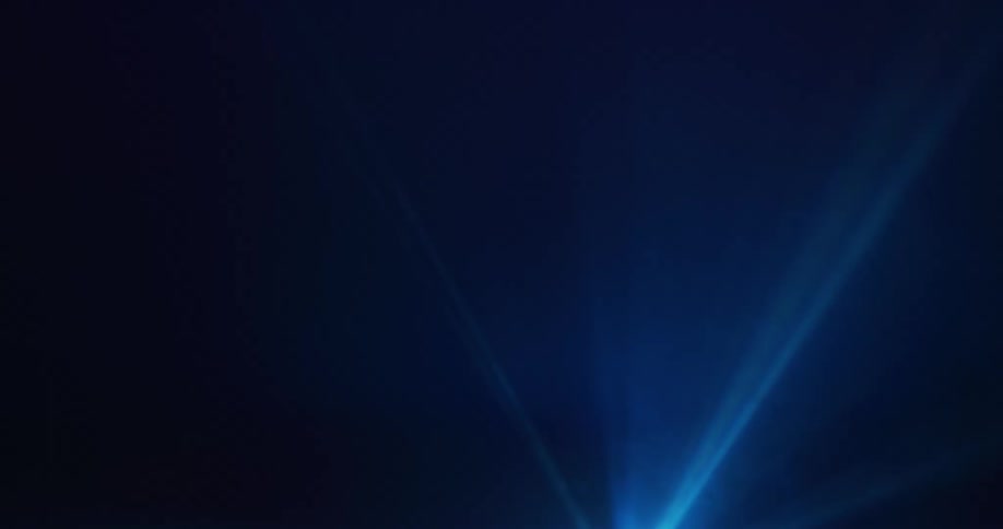 There is movement inside rays of blue light as they shine across the darkness