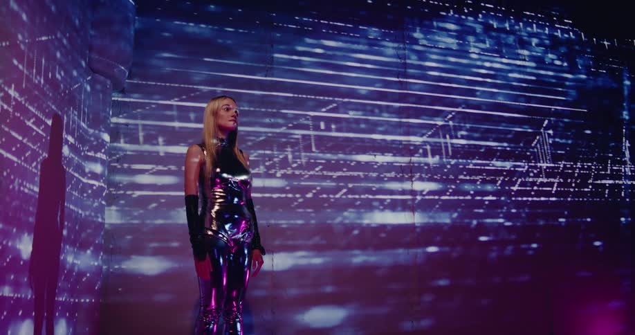A woman stands on stage with bright lights and smoke as she waits to perform