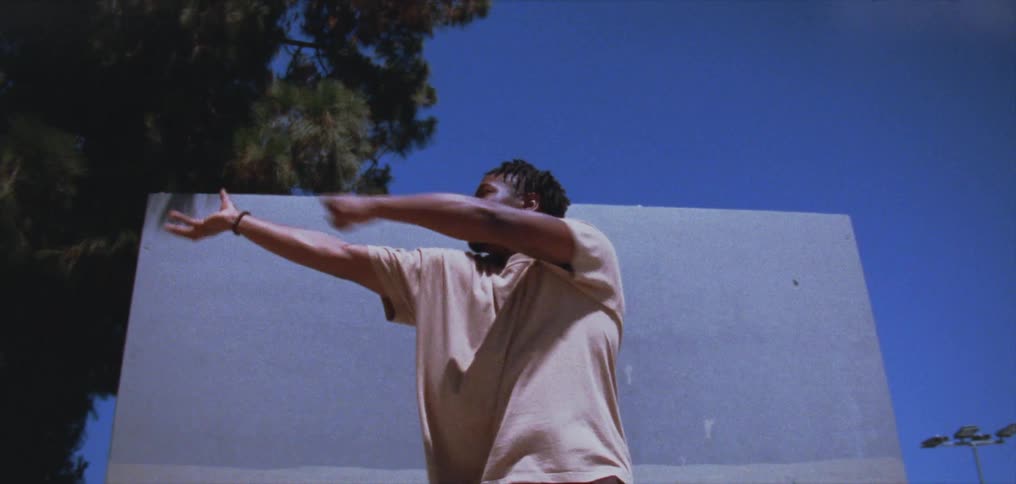 Male dancer dances outdoors near freestanding wall