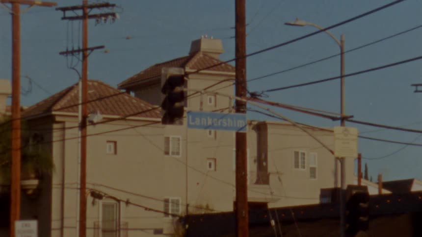A nonworking traffic light hangs over a city intersection