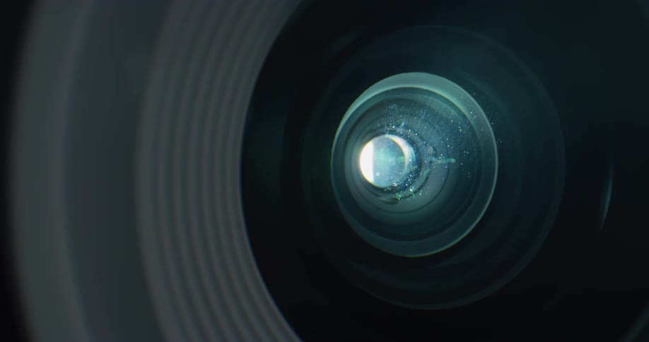 Dust particles floating in front of the lens of a working film projector