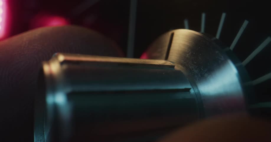 Light shines on a persons fingers as they turn a dial on an electronic device