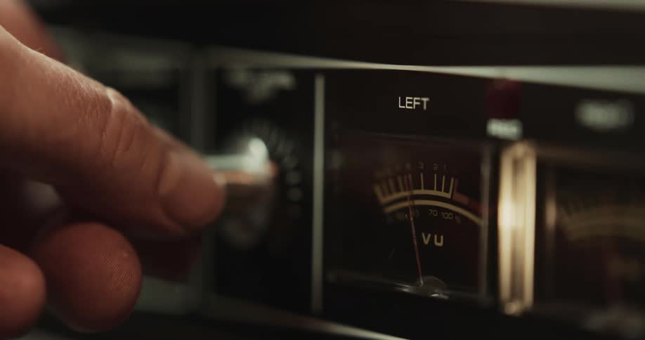 A man turns a dial on a vintage stereo
