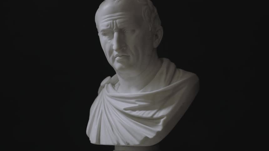 A male marble bust against a black background